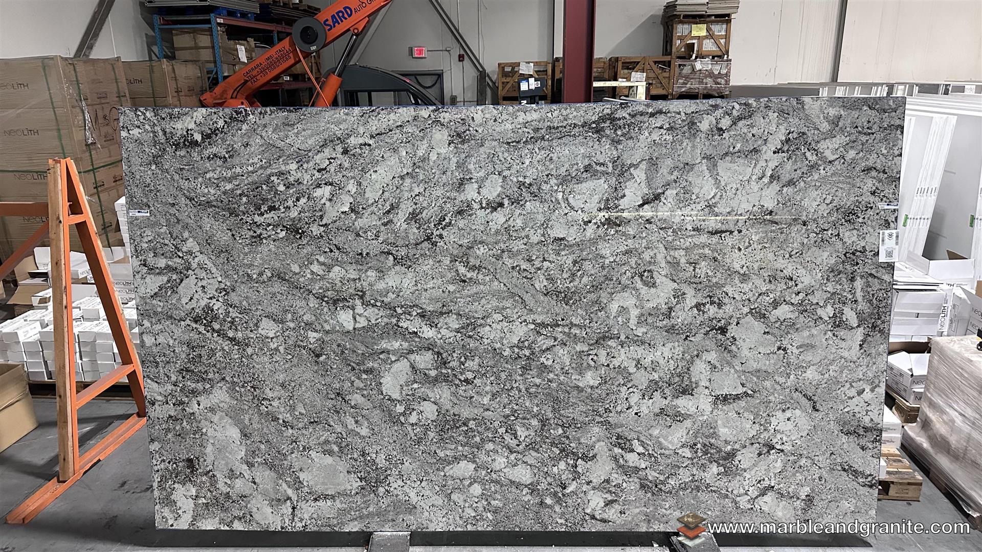 Alaskan White granite countertop material with light background and natural mineral movement